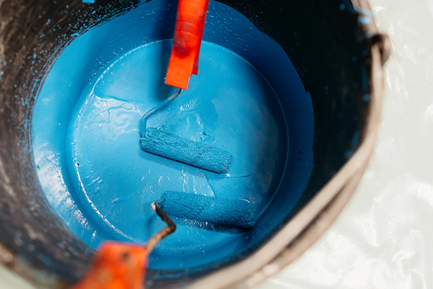 Blue waterborne industrial coating being mixed in a container