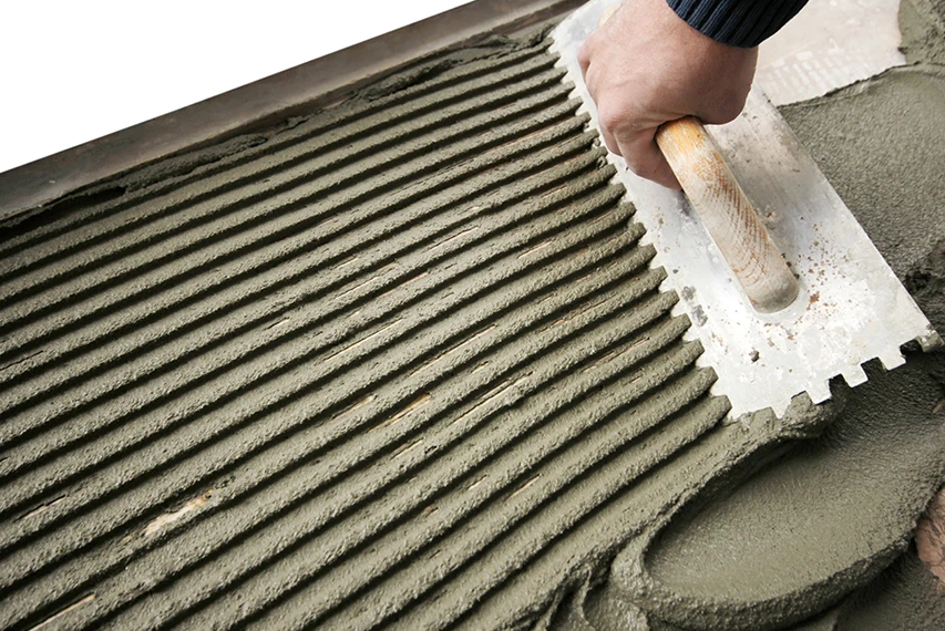 Notched trowel spreading cement-based tile adhesive with HEMC support