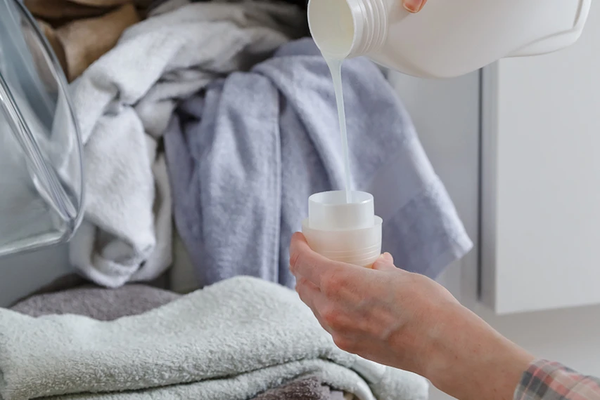 Liquid fabric softener being poured into a cap with HEMC support