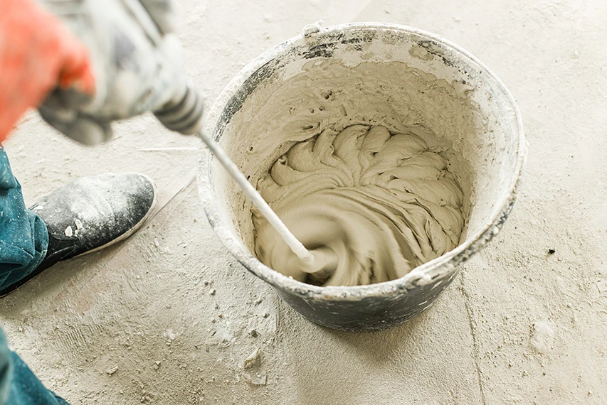 Lightweight cement plaster being mixed in a bucket with HEMC support